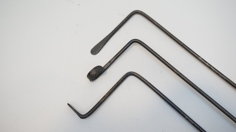 Pu&ograve; includere: Tre strumenti in metallo con estremit&agrave; di forme diverse. Gli strumenti sono piegati ad un angolo di 90 gradi e sono disposti in uno schema sfalsato.