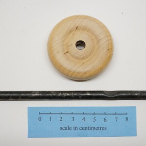 K&ouml;nnte beinhalten: Ein Holzrad mit einem Loch in der Mitte und einer Metallstange, die 8 Zentimeter lang ist.
