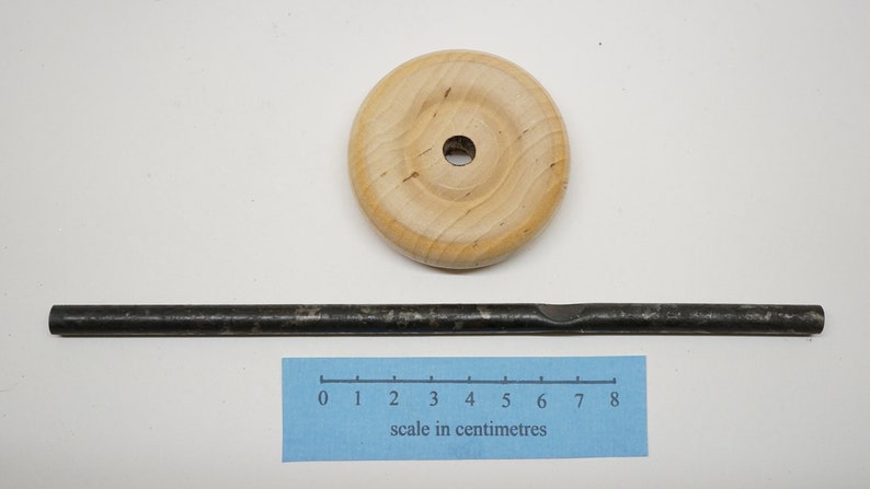 K&ouml;nnte beinhalten: Ein Holzrad mit einem Loch in der Mitte und einer Metallstange, die 8 Zentimeter lang ist.