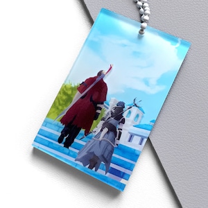 Op de afbeelding: Een rechthoekige acryl bedel met een anime-stijl illustratie. De illustratie toont twee figuren in een fantasiewereld, een in rood en een in grijs, tegen een blauwe lucht en architecturale elementen. Een kralenketting is bevestigd.