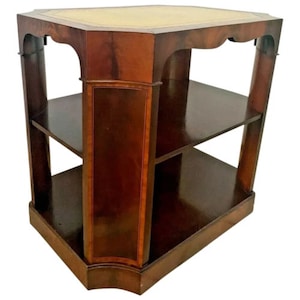 May include: A dark wood end table with two shelves and a decorative top. The table has a rectangular base and a slightly rounded top.