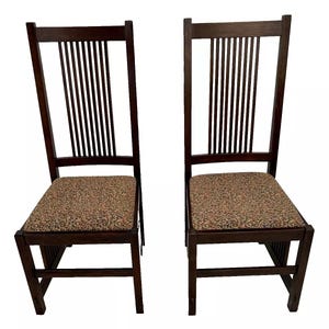 May include: Two dark brown wooden chairs with vertical slat backs and upholstered seats with a floral pattern.