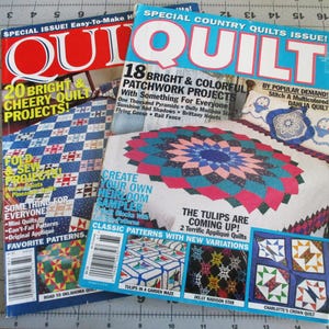 May include: Two issues of Quilt magazine featuring colorful patchwork quilt projects. The cover of the first issue features a quilt with a checkered pattern and the text "20 Bright & Cheery Quilt Projects!" The cover of the second issue features a quilt with a floral pattern and the text "18 Bright & Colorful Patchwork Projects".