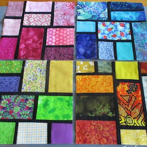 May include: A quilt block with a stained glass design featuring a variety of colorful fabrics. The quilt block is made up of 16 smaller squares, each with a different pattern. The squares are arranged in a grid pattern, and the seams are outlined in black.