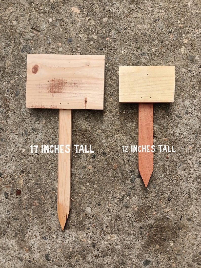 May include: Two wooden signs with stakes, one is 17 inches tall and the other is 12 inches tall. Both signs are blank and ready to be personalised.