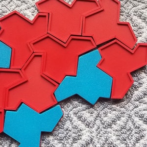 May include: A set of red and blue geometric puzzle pieces. The pieces are shaped like stars and have a textured surface.