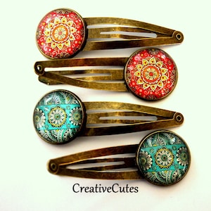 May include: Four bronze hair clips with colorful patterned glass cabochons. The patterns are red, orange, yellow, and blue.