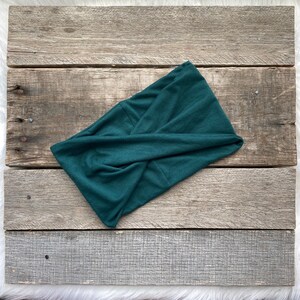 May include: A dark green fabric headband with a twisted knot design.