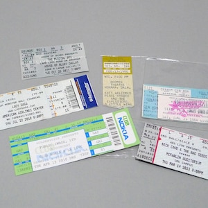 May include: A collection of six rectangular paper concert tickets featuring various event details, dates, and venues including Lady Gaga at American Airlines Center, Nick Cave and the Bad Seeds at McFarlin Auditorium, and Public Image Ltd at Club Nokia.