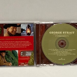 May include: A George Strait Christmas CD with a green CD inside. The CD inlay has a picture of George Strait on it. The text on the CD case reads 'George Strait, Fresh Cut Christmas' and '1. Joy To The World 2. We Three Kings 3. Silent Night 4. Jingle Bells 5. O Come All Ye Faithful 6. Up On The Housetop 7. We Wish You A Merry Christmas 8. O Christmas Tree 9. Hark! The Herald Angels Sing 10. Deck The Halls'.