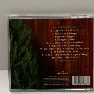 May include: A George Straight Christmas CD with green pine tree on the left side. The back of the case lists the following songs: Joy To The World, We Three Kings, Silent Night, Jingle Bells, O Come, All Ye Faithful, Up On The Housetop, We Wish You A Merry Christmas, O Christmas Tree, Hark, The Herald Angels Sing, Deck The Halls.
