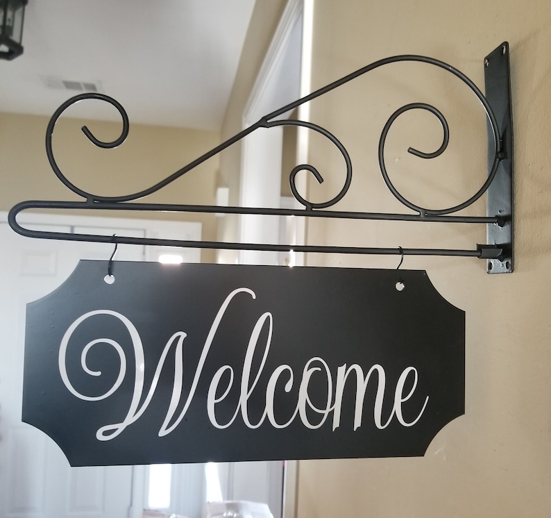 This is a custom metal hanging sign with a hanging rod and hanging hardware which are included. The sign is black with white writing. The writing is able to be perosnalized by you choosing your font and font color.