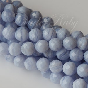 May include: Close-up of a strand of light blue agate beads. The beads are faceted and have a natural, striated pattern.