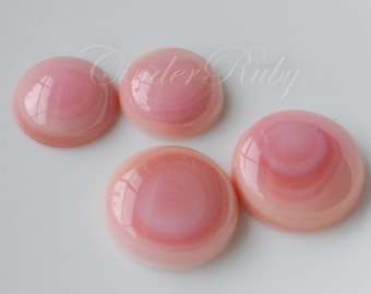 May include: Four pink and white shell cabochons with a glossy finish. The cabochons are round and have a swirling pattern.