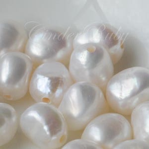 May include: A collection of white baroque pearls, each with a unique shape and luster. The pearls are smooth and have a slightly iridescent sheen.