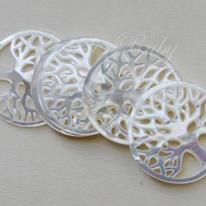 May include: Four white mother of pearl round ornaments with a tree of life design.