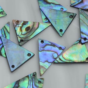 May include: A collection of triangular abalone shell pendants featuring iridescent swirls of blue, green, and purple. Each piece has two small circular holes drilled near the corners, showcasing the natural, polished, and shimmering surface texture.