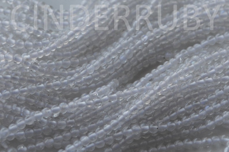May include: A strand of small, round, translucent white beads. The beads have a slightly iridescent sheen.