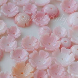May include: A collection of pink and white shell flower beads. The beads are made of natural shell and have a delicate, feminine look.