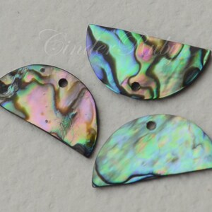 May include: Three iridescent abalone shell half-circle pendants with holes for hanging. The shells have a variety of colors, including green, blue, purple, and brown.