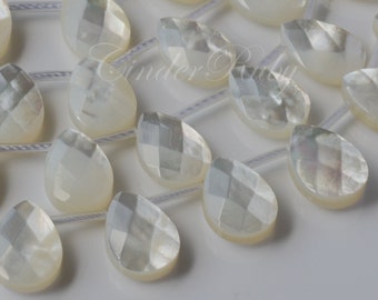 May include: A strand of white mother of pearl teardrop beads with a faceted design. The beads are strung on a clear elastic cord.