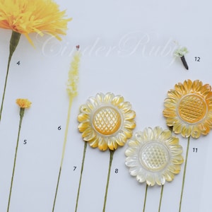 May include: Assortment of yellow and white sunflower-shaped embellishments with a textured design. The embellishments are arranged on a white surface with numbers 6, 7, 8, 11, and 12 visible.