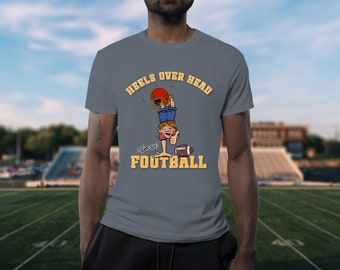 May include: A gray t-shirt with a cartoon illustration of a person doing a handstand with a football helmet on their head. The text "Heels Over Head also at FOOTBALL" is printed on the shirt.