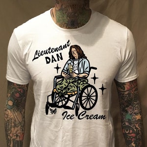 May include: White t-shirt with a graphic of a man in a wheelchair holding an ice cream cone. The text "Lieutenant DAN" and "Ice Cream" are printed on the shirt.