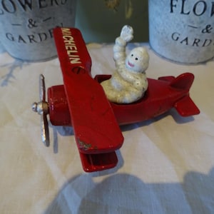 Vintage cast iron counter top  advertising Michelin man flying a plane in great condition
