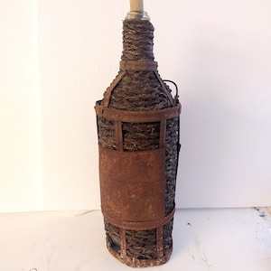 Vintage straw and metal demijohn.Handcrafted vintage blown glass straw and metal demijohn.
