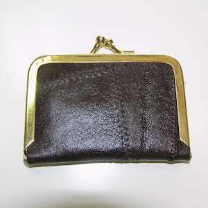 May include: A small, dark brown coin purse with a gold-colored metal frame and clasp. The purse has a textured surface and a rectangular shape. The clasp is a simple, decorative design.