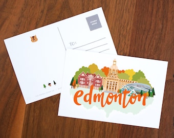 May include: Two white postcards with illustrations and text. One postcard features a colorful illustration of buildings with the word "edmonton" in orange. The other postcard has a squirrel illustration and space for a stamp.
