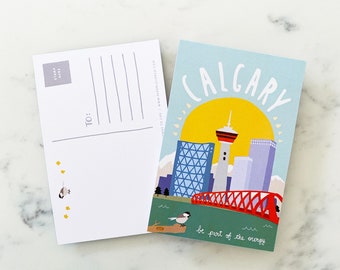 May include: A postcard with a blue and green background featuring a stylized illustration of the Calgary skyline. The postcard says "CALGARY" in white text and "be part of the energy" in black text. The postcard has a white border.