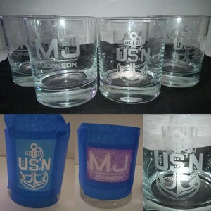 May include: Three clear glass tumblers with etched designs. One tumbler has the initials "MJ" and the name "JOHNSON" etched on it. The other two tumblers have the acronym "USN" and an anchor etched on them.