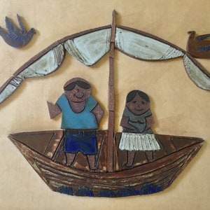 May include: A ceramic wall art piece depicting a boat with two figures and a sail. The boat is brown with blue accents, and the figures are wearing blue and gray clothing. Two blue birds are flying above the boat.