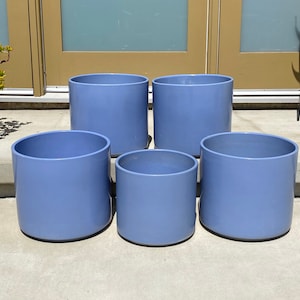 May include: Five blue ceramic planters of varying sizes. The planters are cylindrical and have a smooth, matte finish.