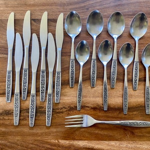 May include: A set of silverware with a decorative floral pattern. The set includes knives, spoons, and a fork.