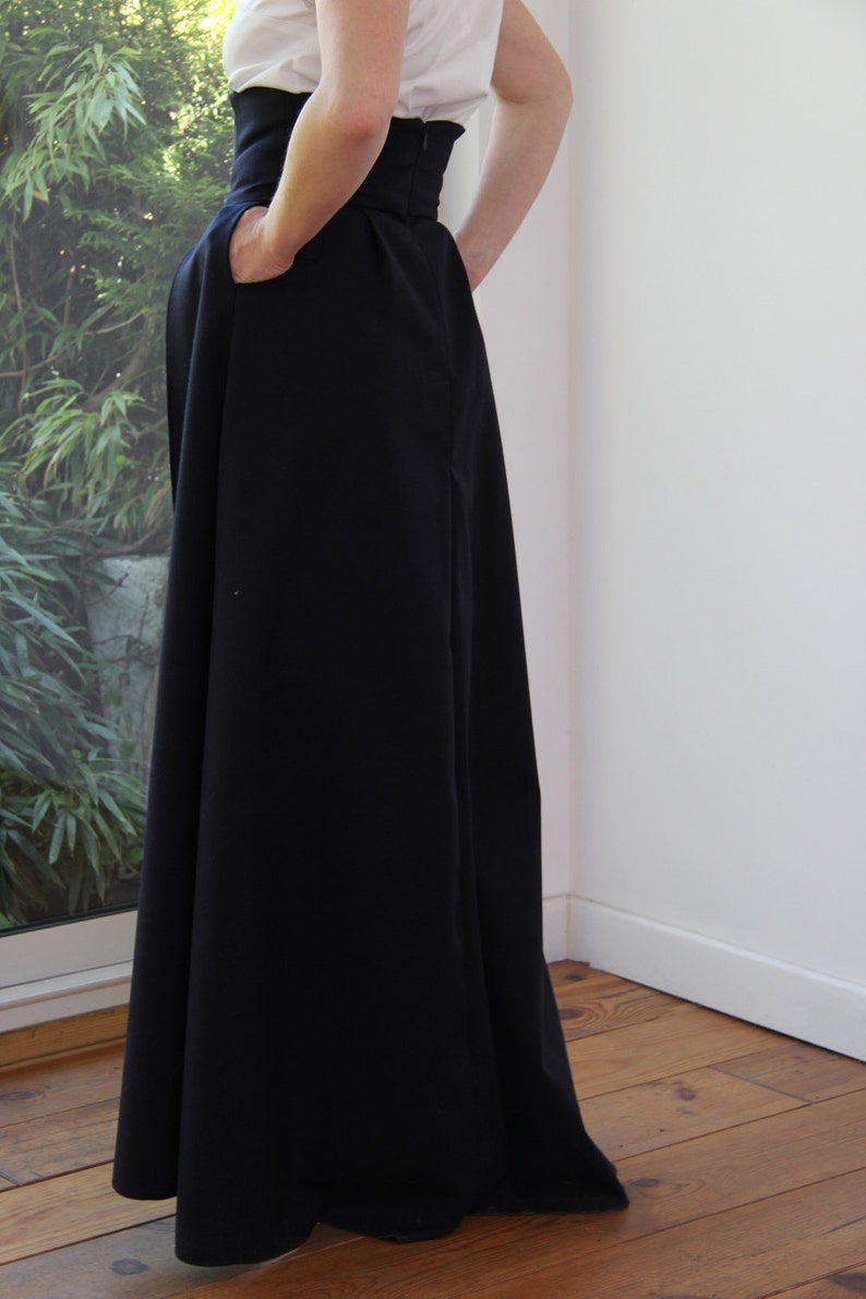 May include: A black high-waisted maxi skirt with a wide waistband and a flowing silhouette.