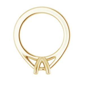 May include: A gold ring setting with a prong setting for a center stone.
