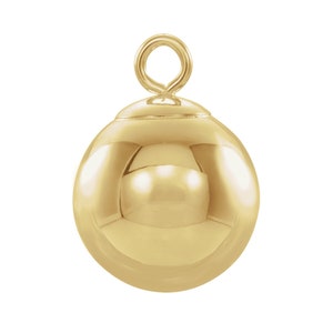 May include: A gold-colored metal ball charm with a loop at the top. The ball is smooth and shiny.