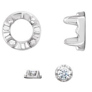 May include: A set of silver-toned metal earring settings with a round prong setting for a gemstone. The settings are designed to hold a round gemstone in place.