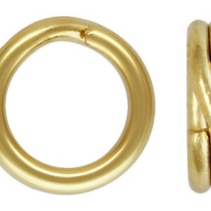 May include: Two gold-colored jump rings, one is a simple round ring, the other is a twisted ring.