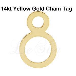 May include: A 14kt yellow gold chain tag in the shape of a figure eight. The tag has two circles, one inside the other.