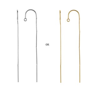 May include: Two pairs of long, thin chain earrings. One pair is silver and the other is gold.