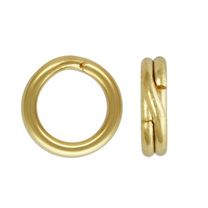 May include: Two gold-colored metal jump rings. One ring is open and the other is closed.