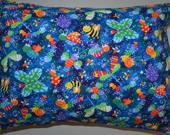 May include: A blue pillowcase with a colorful pattern of bugs, butterflies, and stars. The pattern includes red, yellow, green, orange, and purple.