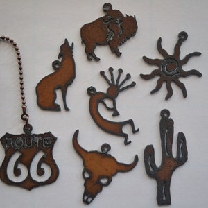 May include: A set of eight metal Southwestern-themed fan pull charms. The charms include a buffalo, a coyote, a sun, a cactus, a skull, a Native American dancer, and a Route 66 sign.