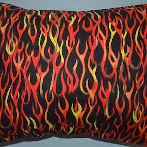 May include: A black pillow with a flame pattern in red, yellow, and orange.