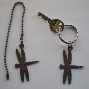 May include: Two dragonfly-shaped metal keychains with a copper chain. One keychain is attached to a key ring and the other is attached to a longer chain.