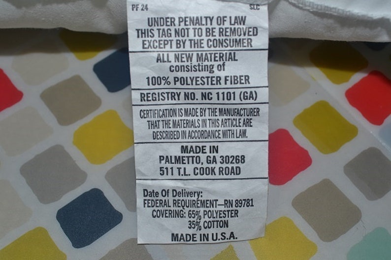 May include: White tag with black text stating "Under penalty of law this tag not to be removed except by the consumer. All new material consisting of 100% polyester fiber. Registry No. NC 1101 (GA). Certification is made by the manufacturer that the materials in this article are described in accordance with law. Made in Palmetto, GA 30268 511 T.L. Cook Road. Date of Delivery: Federal Requirement-RN 89781 Covering: 65% polyester 35% cotton Made in U.S.A."